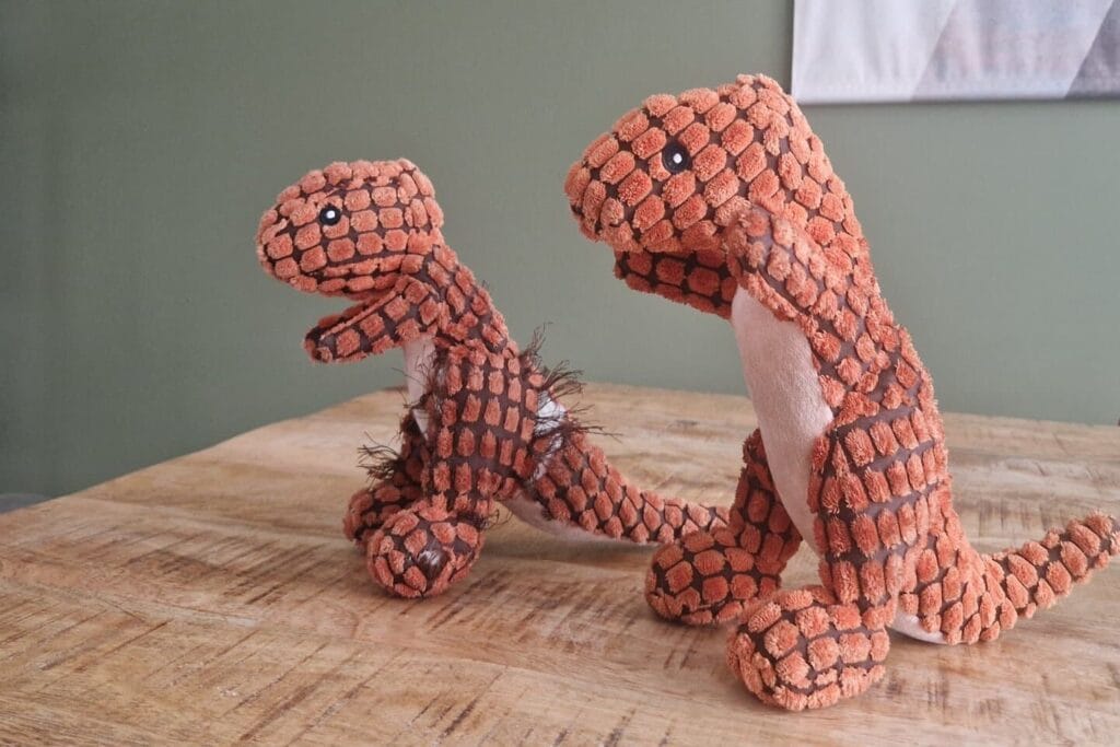 Op deze afbeelding zie je Teddy's oude en nieuwe dino hondenknuffel