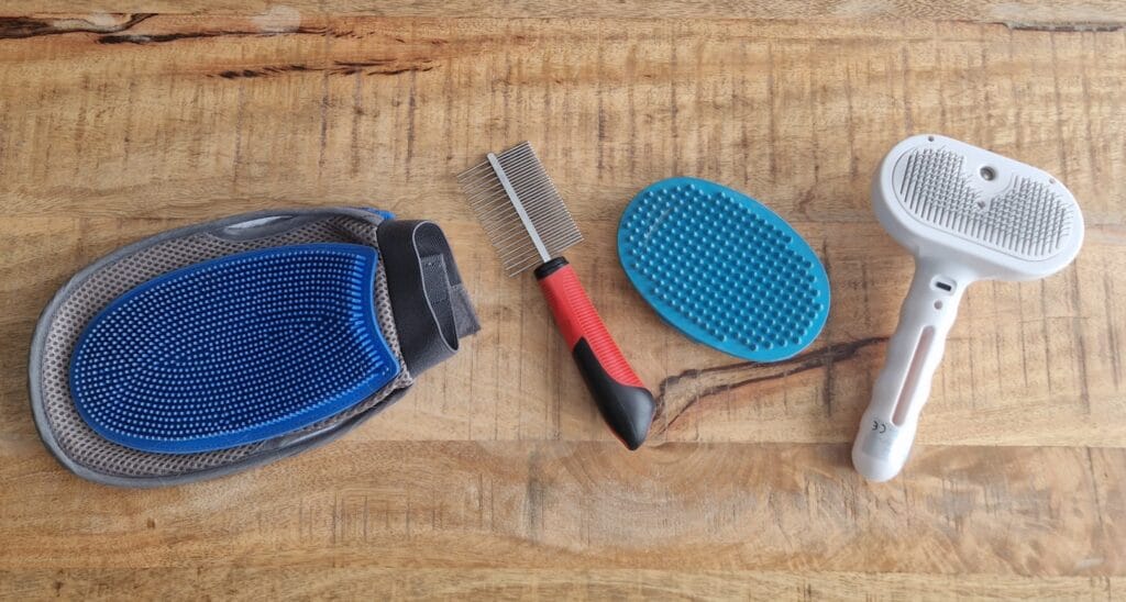 Verschillende borstels die ik gebruik voor mijn labrador Teddy, waaronder een rubberen borstel, kam en stoomborstel